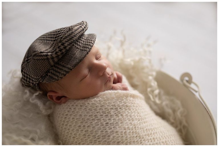 Newborn portrait boy photography in studio with baby golfing hat. 