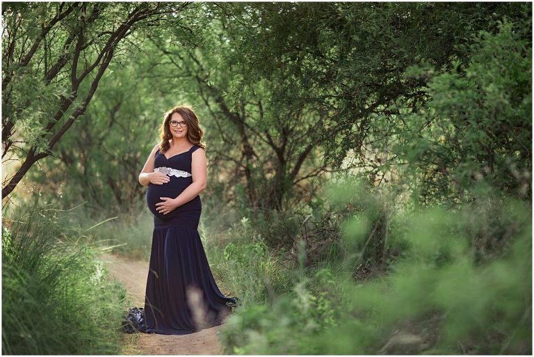 Maternity pose in navy gown with green landscape in Sierra Vista Arizona.